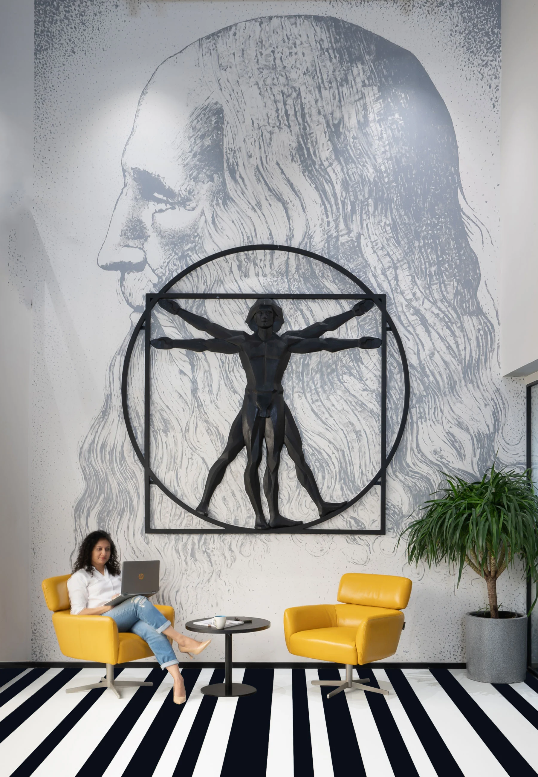 A woman seated in a chair before a large mural in the Centrix Office Reception area.