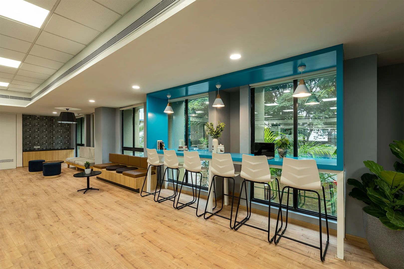 An office featuring a blue wall and elegant wooden floors, creating a modern and inviting workspace atmosphere.